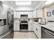 The bright kitchen features stainless steel appliances, white cabinets, and light countertops for a clean aesthetic at 8244 Brentwood Rd, Seminole, FL 33777