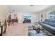 Open-concept living room with tile flooring, a comfortable sofa, and a dining area for seamless living at 8244 Brentwood Rd, Seminole, FL 33777