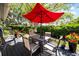 Outdoor patio with table, chairs, red umbrella, and lush greenery, perfect for relaxing and entertaining at 8244 Brentwood Rd, Seminole, FL 33777