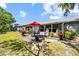 A covered patio offers outdoor seating, flowerpots, and landscaping, with a lush lawn in the background at 8244 Brentwood Rd, Seminole, FL 33777