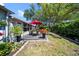 A well-maintained backyard showcases outdoor seating with colorful foliage creating a serene, natural retreat at 8244 Brentwood Rd, Seminole, FL 33777