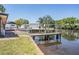 Waterfront backyard featuring a wooden dock, boat lift, canal view, and access to waterfront activities at 8816 Memorial Hwy, Tampa, FL 33615