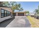 Exterior view of the home showcasing the driveway, garage, and canal access at 8816 Memorial Hwy, Tampa, FL 33615