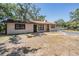 Exterior of home featuring a well-maintained lawn, front door, and mature trees at 8816 Memorial Hwy, Tampa, FL 33615