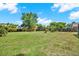 The large grassy backyard is enclosed with a wooden fence, and features various trees and plants at 9603 Sunnyoak Dr, Riverview, FL 33569