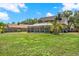 Spacious backyard view of a green two-story home with a screened patio, set on a lush green lawn at 9603 Sunnyoak Dr, Riverview, FL 33569
