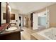 Elegant bathroom with dual vanity, soaking tub, and walk-in shower with a glass door at 9603 Sunnyoak Dr, Riverview, FL 33569