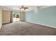 Spacious bedroom featuring plush carpet, ceiling fan, and sliding glass door to the backyard at 9603 Sunnyoak Dr, Riverview, FL 33569