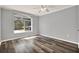 Bright bedroom featuring wood floors, neutral walls, a ceiling fan, and a window with natural light at 9603 Sunnyoak Dr, Riverview, FL 33569