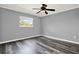 Bedroom featuring wood floors, light gray walls, a ceiling fan, and a window with natural light at 9603 Sunnyoak Dr, Riverview, FL 33569