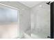 Modern bathroom showcasing elegant marble tile, glass shower doors, and a window for natural light at 9920 Spoonbill E Rd, Bradenton, FL 34209