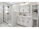Modern bathroom featuring a walk-in shower with glass enclosure, white vanity, and elegant marble tile walls at 9920 Spoonbill E Rd, Bradenton, FL 34209