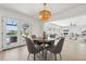 Dining area features a modern chandelier, wood table with seating for four, and a view into the living room at 9920 Spoonbill E Rd, Bradenton, FL 34209
