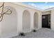 Close up of a well-lit home entrance featuring a covered portico and black framed windows at 9920 Spoonbill E Rd, Bradenton, FL 34209