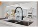 Close-up of a modern kitchen island featuring stainless steel appliances and a view into the living room at 9920 Spoonbill E Rd, Bradenton, FL 34209