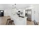 Bright white kitchen featuring stainless appliances, a quartz island, modern lighting and light, wood-look floors at 9920 Spoonbill E Rd, Bradenton, FL 34209