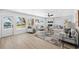 Bright living room with plank floors, fireplace, modern furniture, and views of the canal and boat dockage at 9920 Spoonbill E Rd, Bradenton, FL 34209