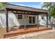 Wooden back patio with a covered roof offers private space and a view of the backyard at 108 5Th St, Belleair Beach, FL 33786