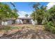 Expansive backyard featuring lush greenery, mature trees, and a covered patio at 108 5Th St, Belleair Beach, FL 33786