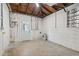 An unfinished basement room, with concrete block walls, door, a window and exposed utilities at 108 5Th St, Belleair Beach, FL 33786