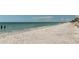 Expansive view of the serene beach with calm turquoise waters and a clear blue sky at 108 5Th St, Belleair Beach, FL 33786