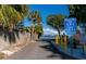 View of a beach entrance with signage, palm trees, and a glimpse of the ocean at 108 5Th St, Belleair Beach, FL 33786