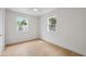 Airy bedroom with hardwood floors, two windows with tropical views, white walls, and a ceiling fan at 108 5Th St, Belleair Beach, FL 33786