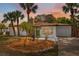 Charming single-story home featuring mature palm trees and a lush landscaped front yard at 108 5Th St, Belleair Beach, FL 33786