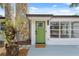 Close up of the front door with stone accents, green door, and new windows at 108 5Th St, Belleair Beach, FL 33786