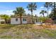 Charming single story home featuring tropical landscaping and a stone chimney at 108 5Th St, Belleair Beach, FL 33786