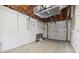 An unfinished garage featuring concrete walls, a roll-up door, and a view of the ceiling and installed mechanics at 108 5Th St, Belleair Beach, FL 33786