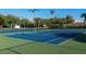 Well-maintained blue and green tennis courts surrounded by lush landscaping and tall trees at 108 5Th St, Belleair Beach, FL 33786