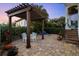 Charming backyard featuring a pergola, outdoor dining area, lush landscaping, and brick paver patio at 108 Bermuda Ave, Tampa, FL 33606