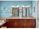 Bathroom featuring a granite countertop, double vanity, wood cabinets and decorative mirrors at 108 Bermuda Ave, Tampa, FL 33606