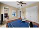 Bedroom with neutral paint, hardwood floors, ceiling fan, white recliner, and a walk-in closet at 108 Bermuda Ave, Tampa, FL 33606