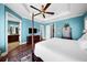 Bright bedroom featuring blue walls, a four-poster bed, hardwood floors and a ceiling fan at 108 Bermuda Ave, Tampa, FL 33606