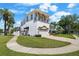 Stunning three-story home with manicured lawn, a paver driveway, and lush landscaping, showcasing curb appeal at 108 Bermuda Ave, Tampa, FL 33606