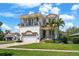 Elegant two-story home with a tile roof, balconies, lush landscaping, and a paver driveway at 108 Bermuda Ave, Tampa, FL 33606