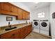 Laundry room features granite countertop, wood cabinets and side-by-side washer and dryer at 108 Bermuda Ave, Tampa, FL 33606