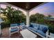 Covered patio with comfortable seating, a coffee table, and views of lush tropical foliage at 108 Bermuda Ave, Tampa, FL 33606