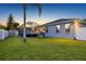The backyard includes a well-kept lawn, mature trees, and a screened-in patio at 10922 Holly Cone Dr, Riverview, FL 33569
