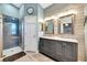 Bright bathroom featuring double vanity with marble countertop, gray cabinets, and tiled walk-in shower at 10922 Holly Cone Dr, Riverview, FL 33569