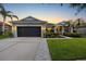 Charming single-story home featuring a well-manicured lawn, mature landscaping, and a two-car garage at 10922 Holly Cone Dr, Riverview, FL 33569