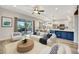 Open-concept living room featuring stylish furnishings, outdoor patio access, and seamless flow to kitchen at 10922 Holly Cone Dr, Riverview, FL 33569