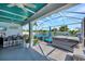 Relaxing covered patio with bar, multiple seating options, spa, and bright overhead lighting at 10922 Holly Cone Dr, Riverview, FL 33569