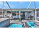 This spacious patio features a bar, seating, spa, grill, TVs and offers beautiful backyard views at 10922 Holly Cone Dr, Riverview, FL 33569