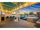 Beautiful, covered outdoor patio features a bar, TV, seating, a spa and tropical landscaping at 10922 Holly Cone Dr, Riverview, FL 33569