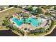 Beautiful aerial view of community pool with palm trees, sun umbrellas, and lounge seating available at 10922 Holly Cone Dr, Riverview, FL 33569