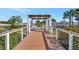 Inviting walkway over a waterway is highlighted with a pergola, plantings and colorful flowers at 10922 Holly Cone Dr, Riverview, FL 33569