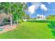 Lush green backyard with a well-maintained lawn, mature trees, and a wooden deck overlooking the canal at 11035 Huron Rd, St Petersburg, FL 33708